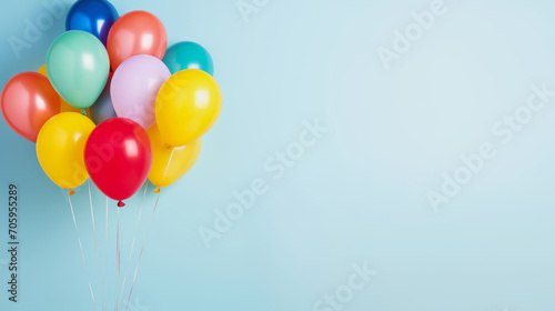 illustration of a bunch of multicolored party balloons against light blue background with copy space