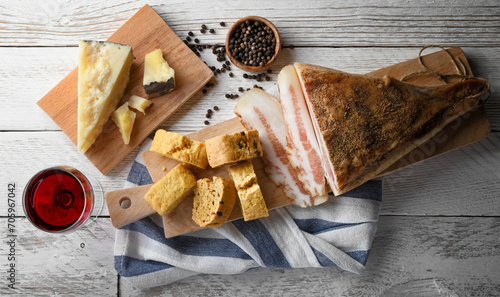 Obraz na płótnie Savory biscuit with pecorino, guanciale and pepper. Cutting board with Italian rustic snack and red wine glass on white wooden background. close-up. w salonie