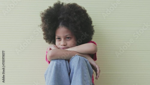 Unhappy girl, Sad child sitting hugging knees alone and lonely photo