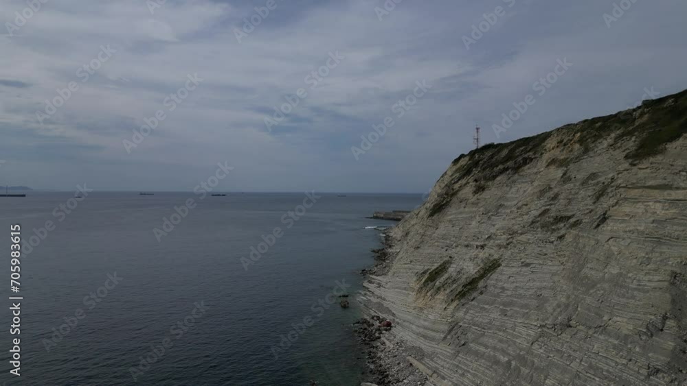 Serene seascape with cliff and distant ships in Bizkaia Serene seascape with cliff and distant ships in Bizkaia