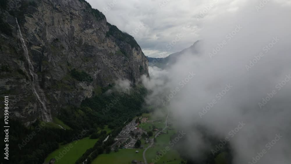 Misty mountain landscape with waterfall in Lauterbrunnen village Misty mountain landscape with waterfall in Lauterbrunnen village
