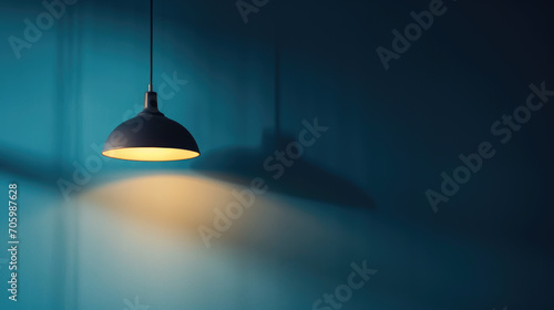 A lamp hangs against a blue wall  casting its light and illuminating the area  with space available for text or presentation.