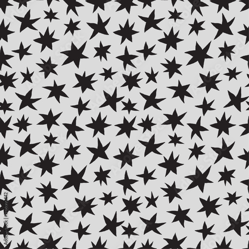 Freehand drawn black stars on gray background seamless pattern