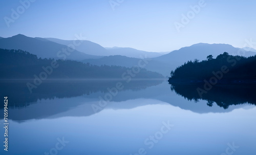 Mountains reflected in blue lake. Glen Affric, Scotland, UK