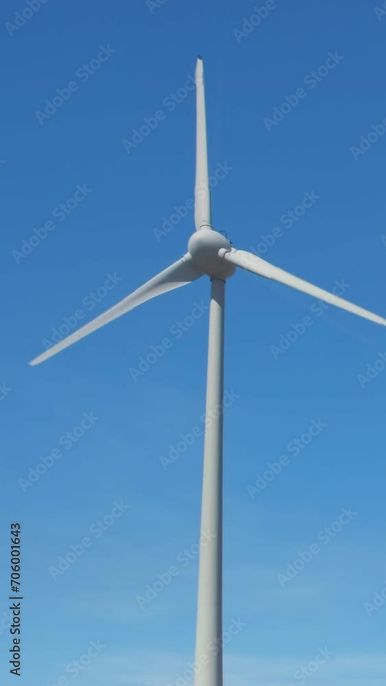 Close shot of wind turbine rotating against clear blue sky on sunny day Close shot of wind turbine rotating against clear blue sky on sunny day