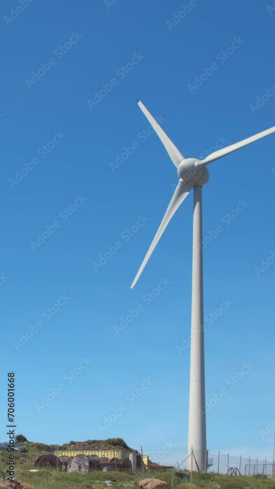 Close-up static shot of wind turbine in hill landscape on sunny day Close-up static shot of wind turbine in hill landscape on sunny day