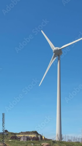 Close-up static shot of wind turbine in hill landscape on sunny day photo