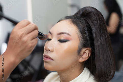 Photo of a woman being made up with a brush in a spa or beauty salon. Concept of women, beauty and self love.