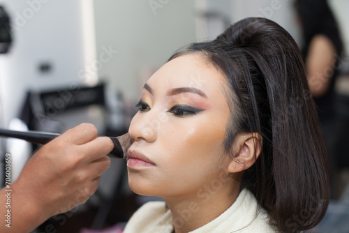 Photo of a woman being made up with a brush in a spa or beauty salon. Concept of women  beauty and self love.
