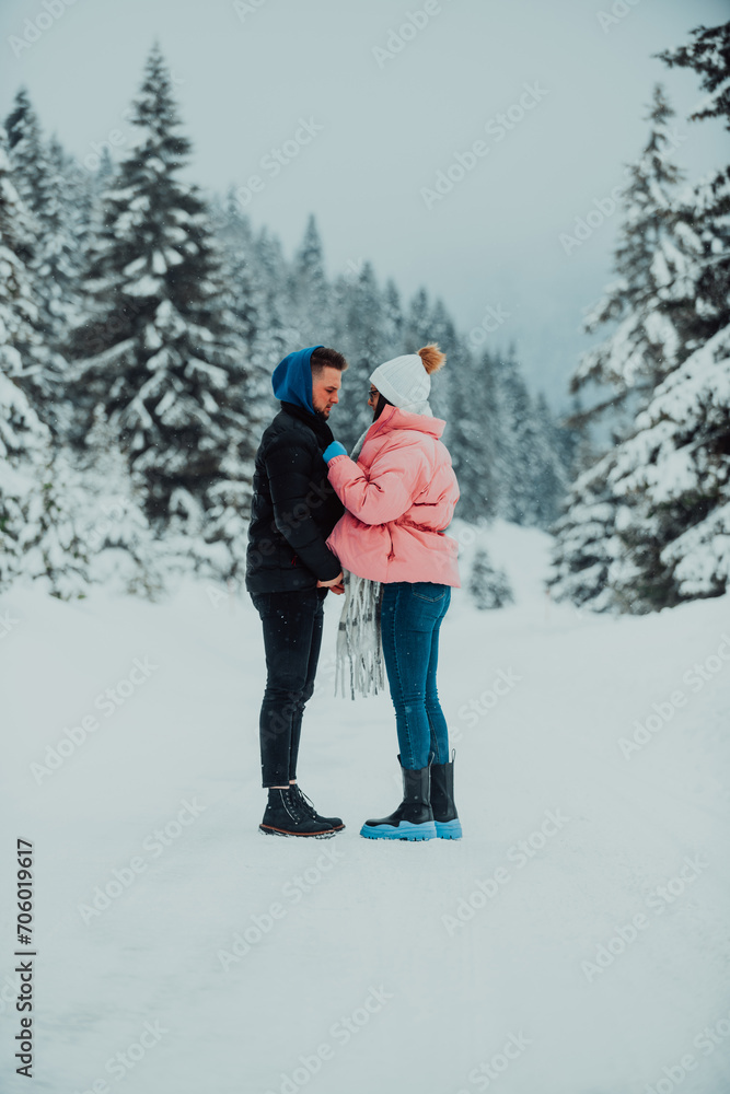 Fototapeta premium On a snowy Valentine's Day, this romantic couple shares warmth, laughter, and tender embraces, creating a blissful winter love story.