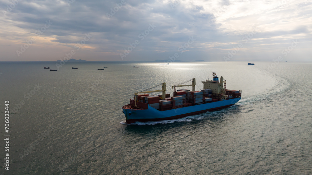 logistic cargo container ship sailing in sea to import export goods and distributing products to dealer and consumers across worldwide, aerial front view