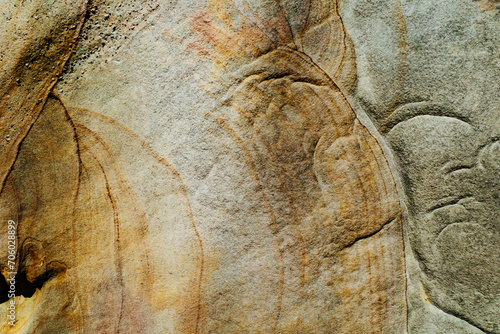 The flat surface of a rough sandstone wall with interesting patterns and colors photo