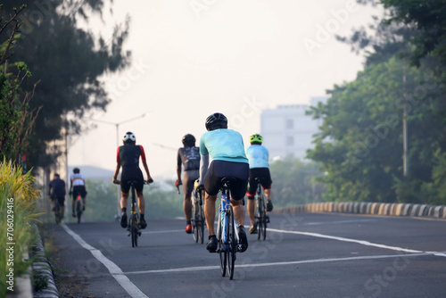 a group of cyclists on the highway, cycling in groups to navigate urban areas while exercising cardio to maintain stamina and body fitness in Indonesia.