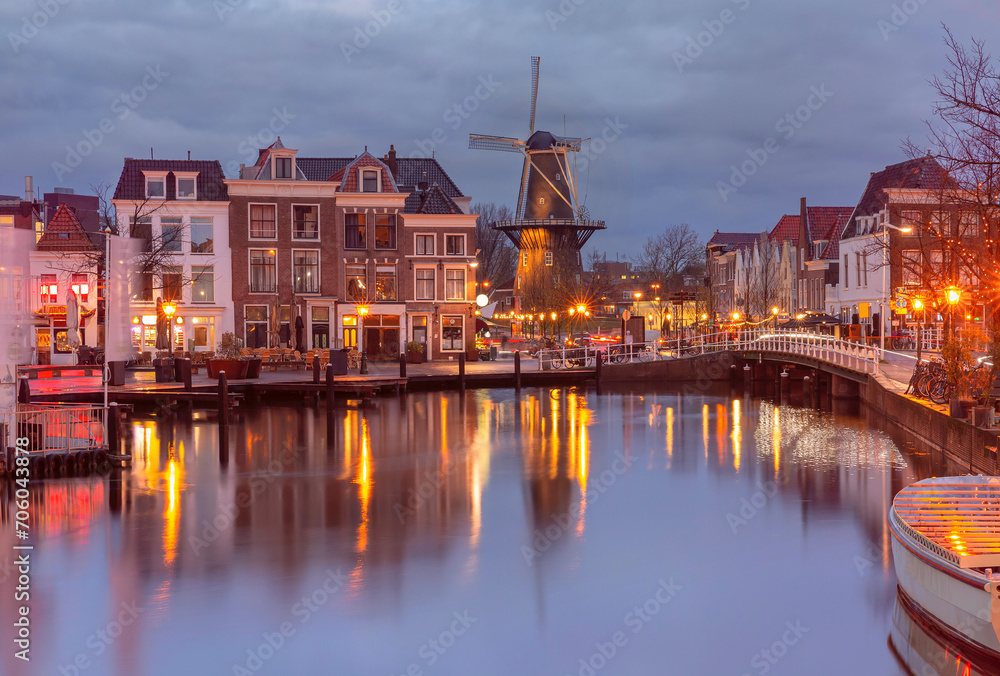 Fototapeta premium Night Leiden canal with Blauwpoortsbrug bridge and Windmill De Valk, South Holland, Netherlands