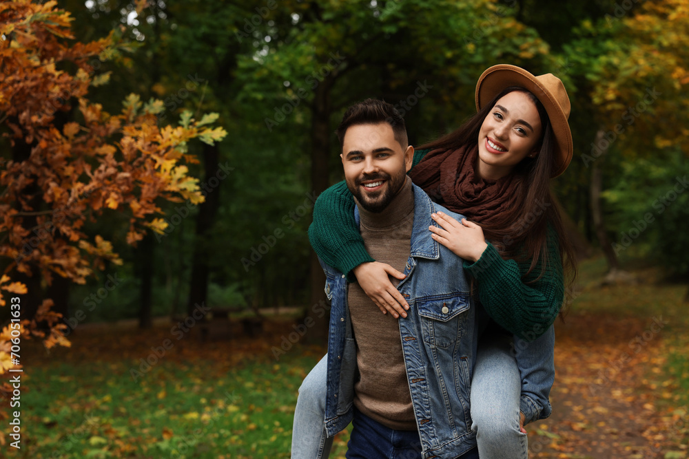 Fototapeta premium Romantic young couple spending time together in autumn park, space for text