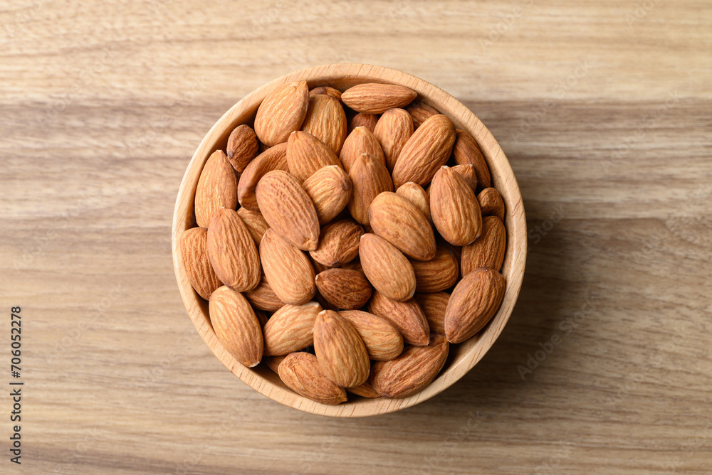 Raw almond in bowl on wooden background, Table top view Raw almond in bowl on wooden background, Table top view