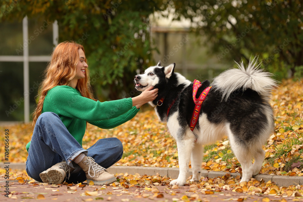 Happy woman with cute Siberian Husky in autumn park
