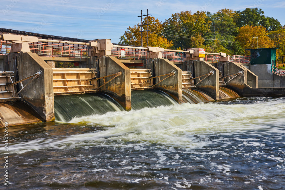 Autumnal Trees and Flowing Dam Water at Huron River, Eye-Level View Autumnal Trees and Flowing Dam Water at Huron River, Eye-Level View