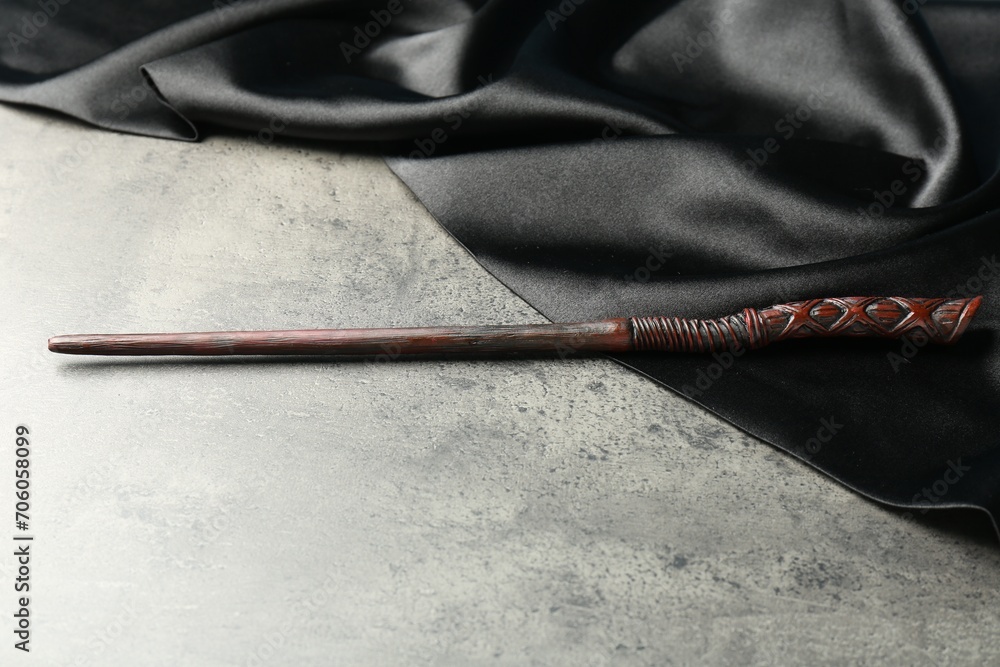 Magic wand and dark cloth on light grey table Magic wand and dark cloth on light grey table