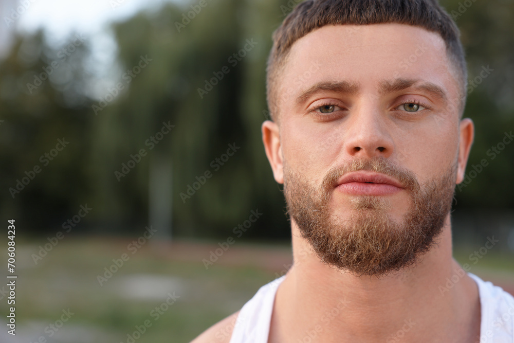 Fototapeta premium Portrait of attractive young man outdoors. Space for text