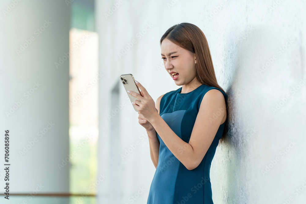 Asian Businesswoman Showing Upset and Frustration Emotion While Using Phone in a Modern Office Building in Downtown Asian Businesswoman Showing Upset and Frustration Emotion While Using Phone in a Modern Office Building in Downtown