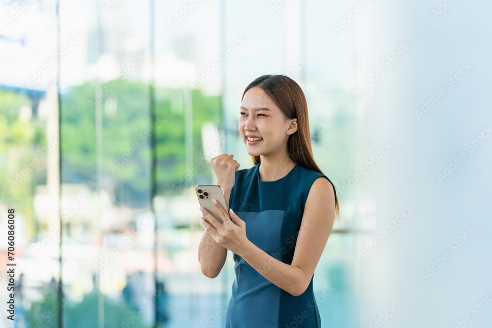 Asian Businesswoman Showing a Successful Yeah while Using Phone in a Modern Office Building in Downtown