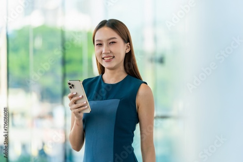 Asian Businesswoman Using Phone in a Modern Office Building in Downtown