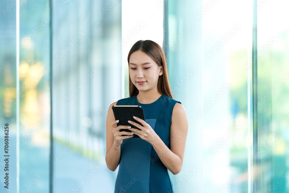 Young Asian Woman Using Digital Tablet to Manage Her Tasks Remotely While Out Of Office Young Asian Woman Using Digital Tablet to Manage Her Tasks Remotely While Out Of Office
