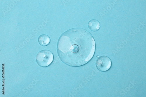 Samples of cosmetic serum on light blue background  flat lay