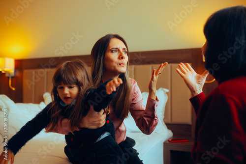 Woman Fighting with her Mother in Law about Raising her Child. Mother and daughter conflict about parenting values in front of the toddler 
