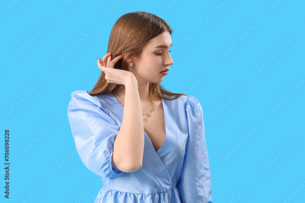 Fashionable young woman in stylish dress on light blue background Fashionable young woman in stylish dress on light blue background