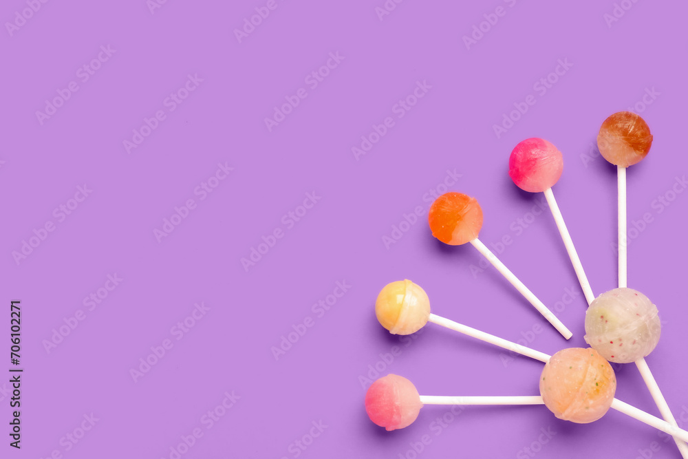 Composition with sweet lollipops on purple background Composition with sweet lollipops on purple background
