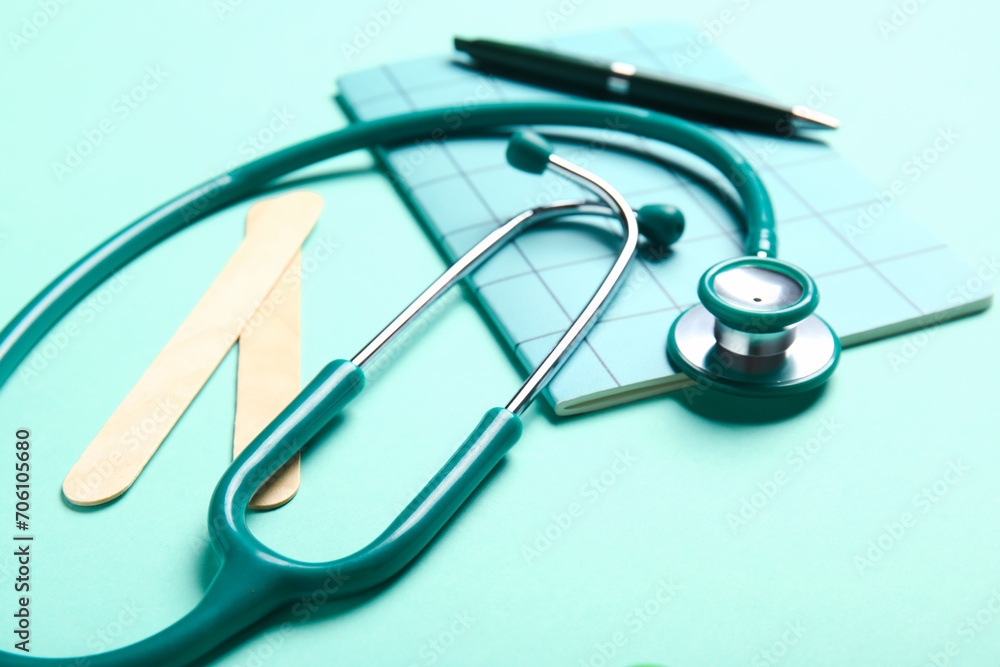Stethoscope and notebook on turquoise background Stethoscope and notebook on turquoise background