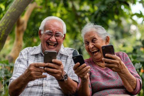 A alegria radiante de um casal de idosos enquanto sorriem, envolvidos em seus smartphones. a imagem traz a importancia da conectividade para os mais velhos. photo