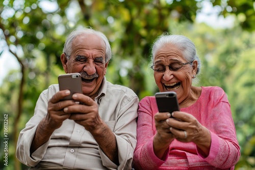 A alegria radiante de um casal de idosos enquanto sorriem, envolvidos em seus smartphones. a imagem traz a importancia da conectividade para os mais velhos. photo