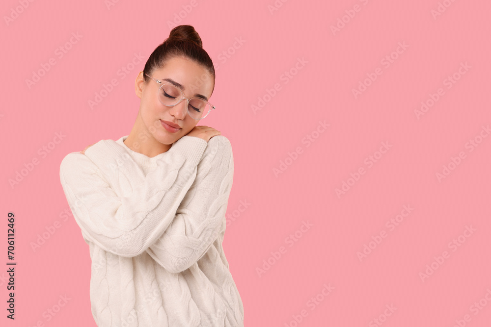 Beautiful young woman in stylish warm sweater on pink background, space for text Beautiful young woman in stylish warm sweater on pink background, space for text