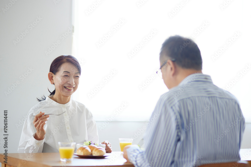 リビングで朝食を食べる日本人のシニア夫婦