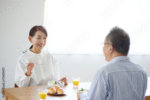 リビングで朝食を食べる日本人のシニア夫婦