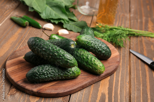 Board with fresh cucumbers for preservation on wooden background