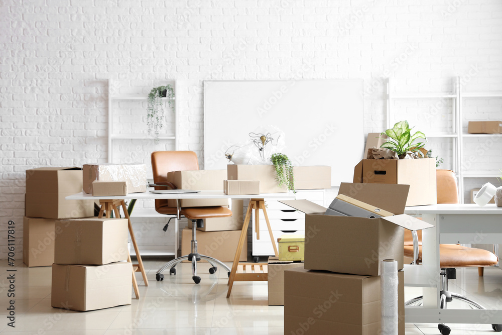Workplaces with cardboard boxes in office on moving day Workplaces with cardboard boxes in office on moving day