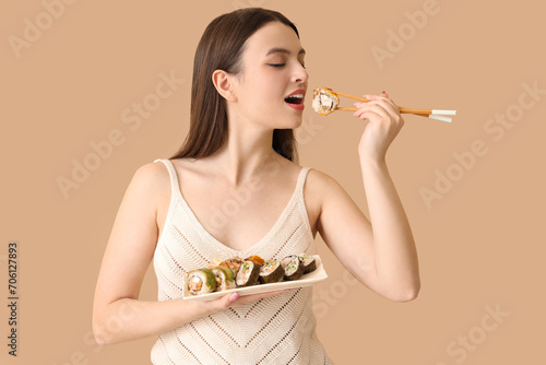 Young woman eating sushi on...