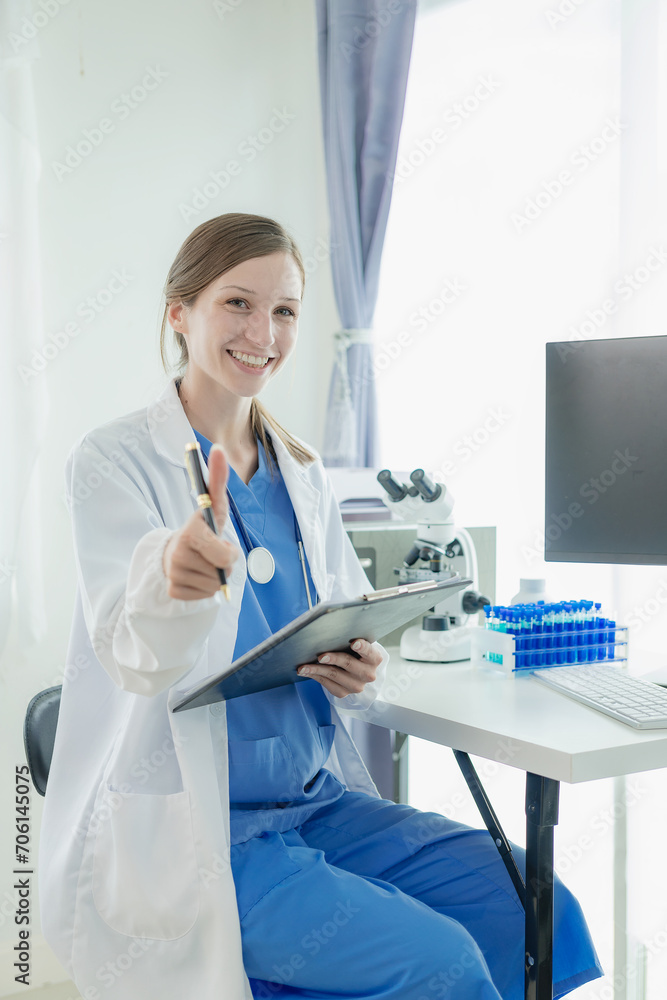 Portrait of a beautiful young female doctor sitting at a table Work in a medical clinic, in a resident's office at a computer Portrait of a beautiful young female doctor sitting at a table Work in a medical clinic, in a resident's office at a computer