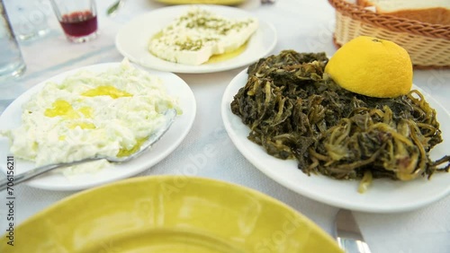 Horta wild greens with tzatziki in olive oil and feta cheese at restaurant on Ikaria island, Greece