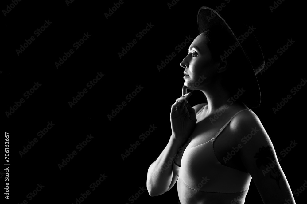 Silhouette of young woman in underwear on dark background