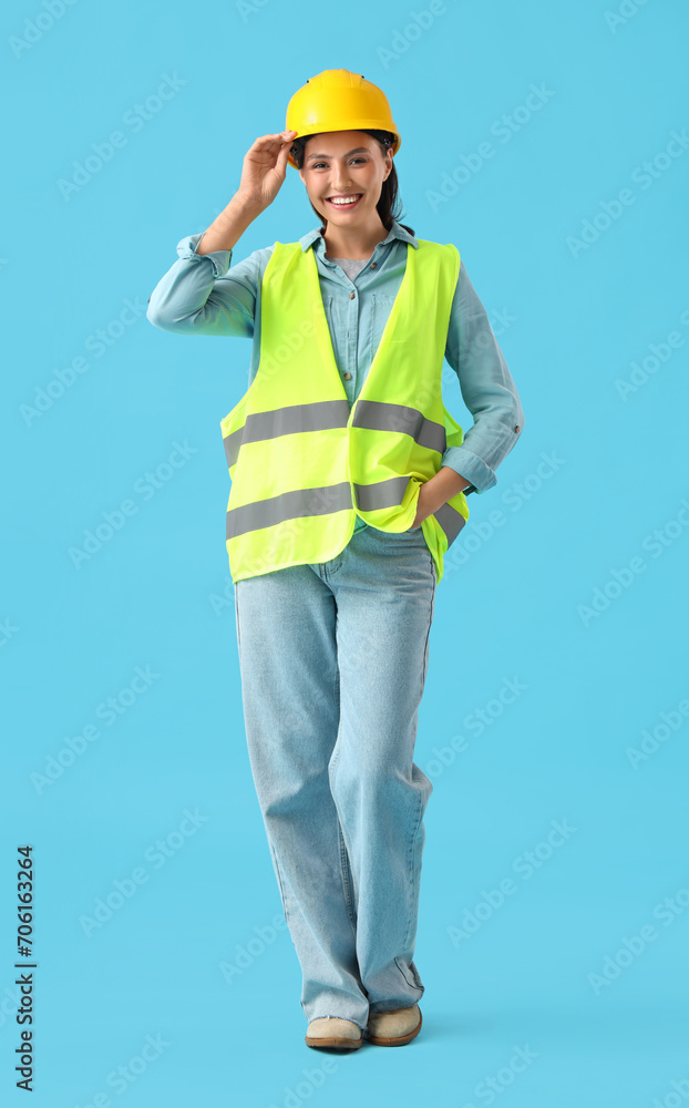 Female worker in reflective vest on blue background Female worker in reflective vest on blue background