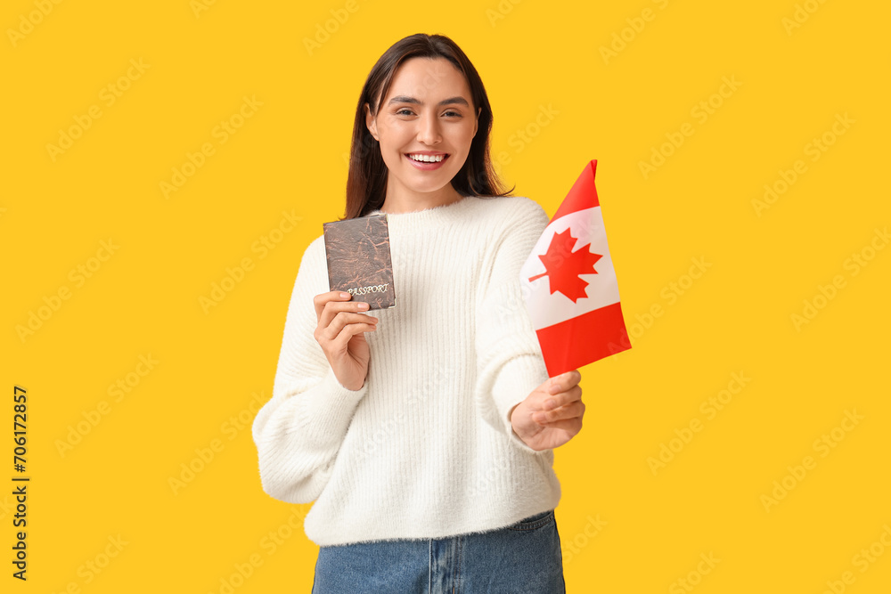 Pretty young woman with flag of Canada and passport on yellow background. Immigration concept Pretty young woman with flag of Canada and passport on yellow background. Immigration concept