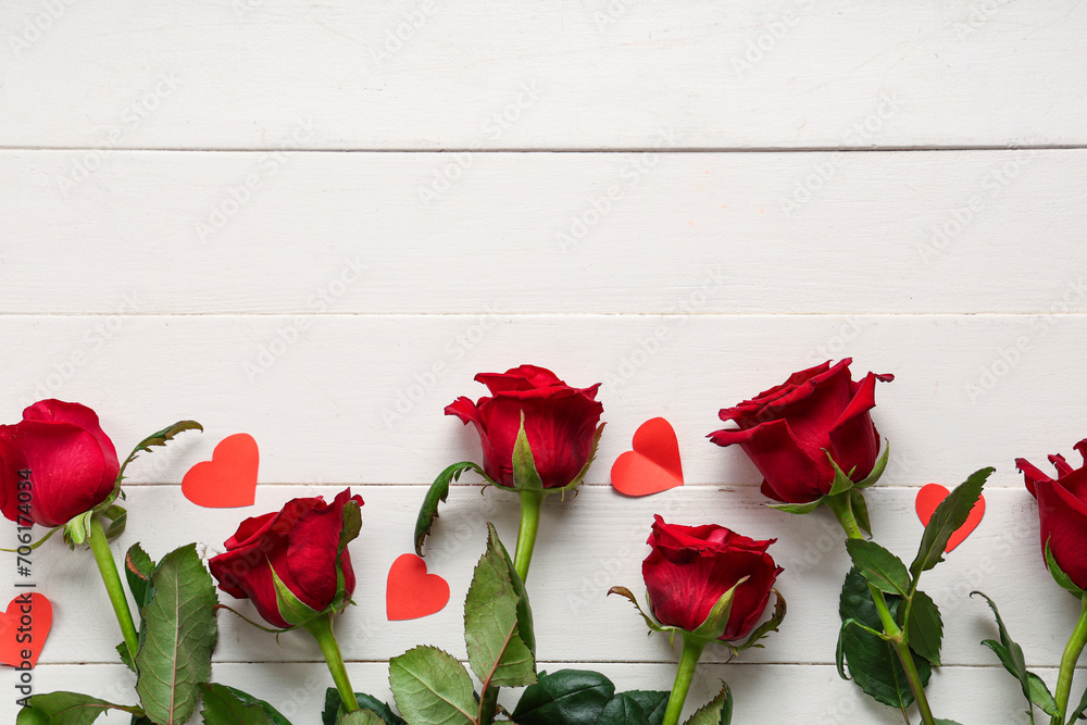 Beautiful roses with paper hearts on white wooden background. Valentine's Day celebration