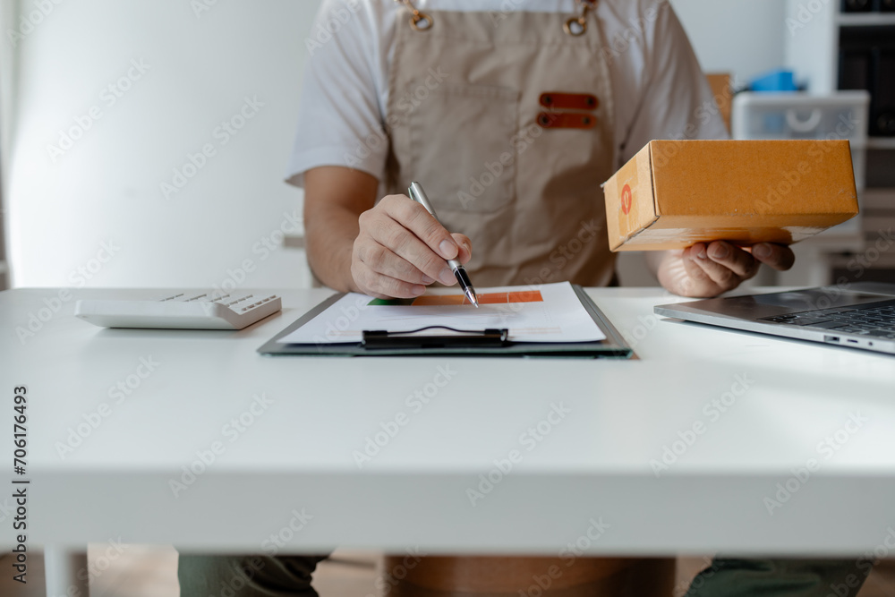 owner of an online store packs products into parcel boxes based on orders from online sales sites, packs products for delivery to addresses via private courier service. Product packaging concept. owner of an online store packs products into parcel boxes based on orders from online sales sites, packs products for delivery to addresses via private courier service. Product packaging concept.