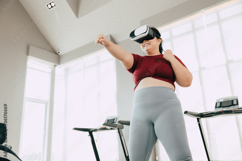 Fototapeta premium fat women with VR headset play visual reality sport game for exercise. people using modern technology for healtcare concept.