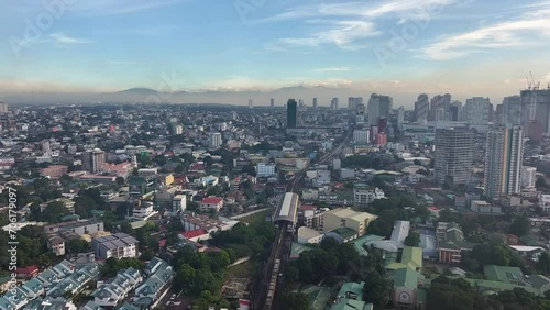 Wallpaper Mural Aerial flight over suburb neighborhood of Manila City with riding train and skyscraper buildings in background at sunset time, Philippines  Torontodigital.ca
